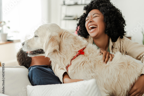 Happy family having fun, playing game with golden retriever dog at home. Animal care, family concept