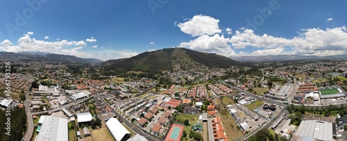 Aerials hot of Ilalo Mountain near Quito city, with lots of houses, sunny day.