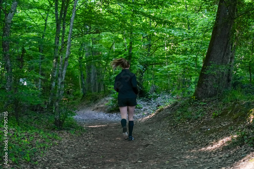 Woman trail running in the forest