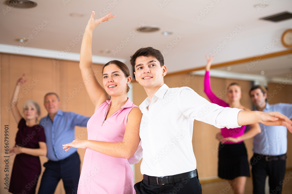 Fototapeta premium Young happy couple performing a paired dance in ballroom