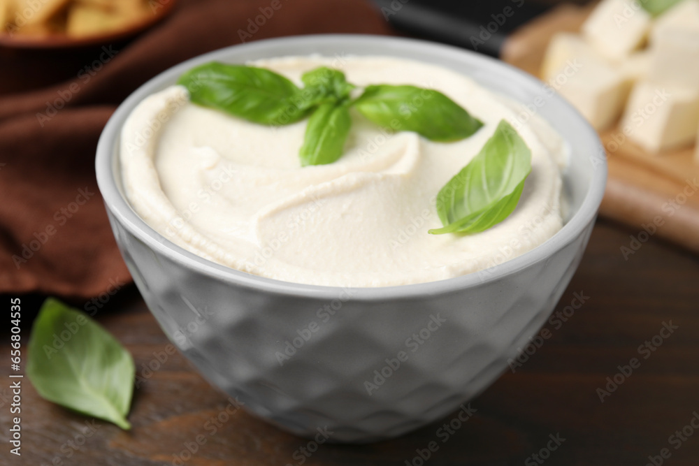 Delicious tofu sauce and basil leaves in bowl on wooden table, closeup Delicious tofu sauce and basil leaves in bowl on wooden table, closeup