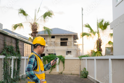 Young Asian engineer is inspecting work wearing a yellow hard hat at a construction site and about building a structure at work. photo