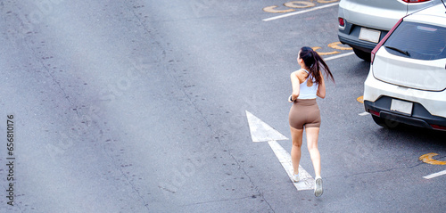 Workout exercise in the morning.Happy slim Asian woman wearing sportswear jogging in the city at sunrise. photo