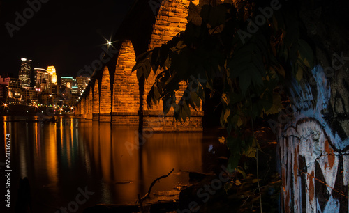 landmark stone arch bridge showing the arches and graffiti at night 