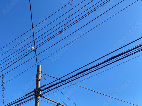 青空の下の電柱と電線