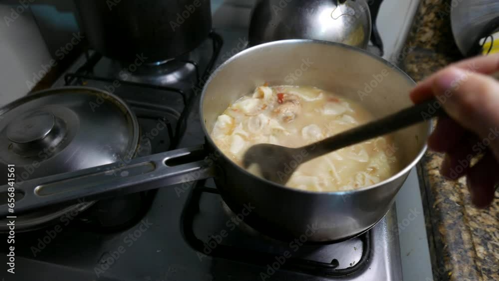 POV, stove top angle: person mixing cappelletti in a pot. A steaming cappelletti pasta pot. Steam coming out of a cappelletti pan. Making cappelletti pasta in a pot. Person stirring cappelletti POV, stove top angle: person mixing cappelletti in a pot. A steaming cappelletti pasta pot. Steam coming out of a cappelletti pan. Making cappelletti pasta in a pot. Person stirring cappelletti