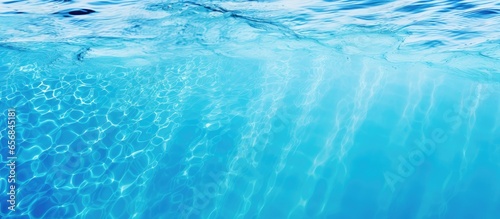 Summer background featuring the textured surface of a blue swimming pool © 2rogan