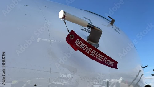 Remove before flight strap pitot cover on a modern jet from outside.daylight. Slowmotion. photo