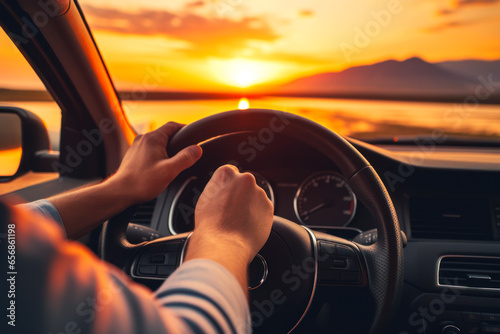 Man driving a car at sunset. View from the driver's seat.