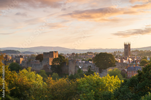 Sunrise colours in the Town of Ludlow in Shropshire, UK with the castle and buildings in the midground and the Clee Hills on the horizon