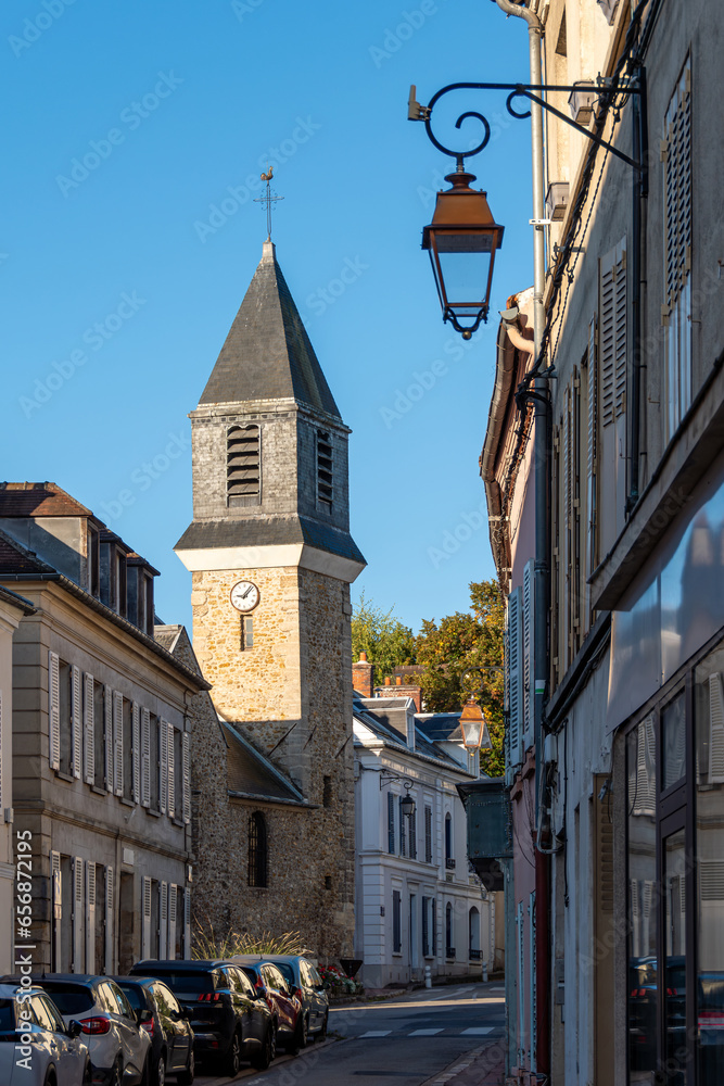 Vue du centre de Viroflay, France, avec la rue Jean-Rey et le clocher de l'église catholique Saint-Eustache, construite au 16ème siècle - obrazy, fototapety, plakaty 