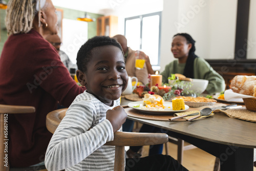 Portrait of african american son with family smiling at thanksgiving dinner table