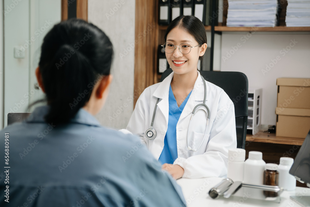 Asia female doctor using clipboard is delivering great news talk discuss results or symptoms with female patient in clinic or hospital Asia female doctor using clipboard is delivering great news talk discuss results or symptoms with female patient in clinic or hospital