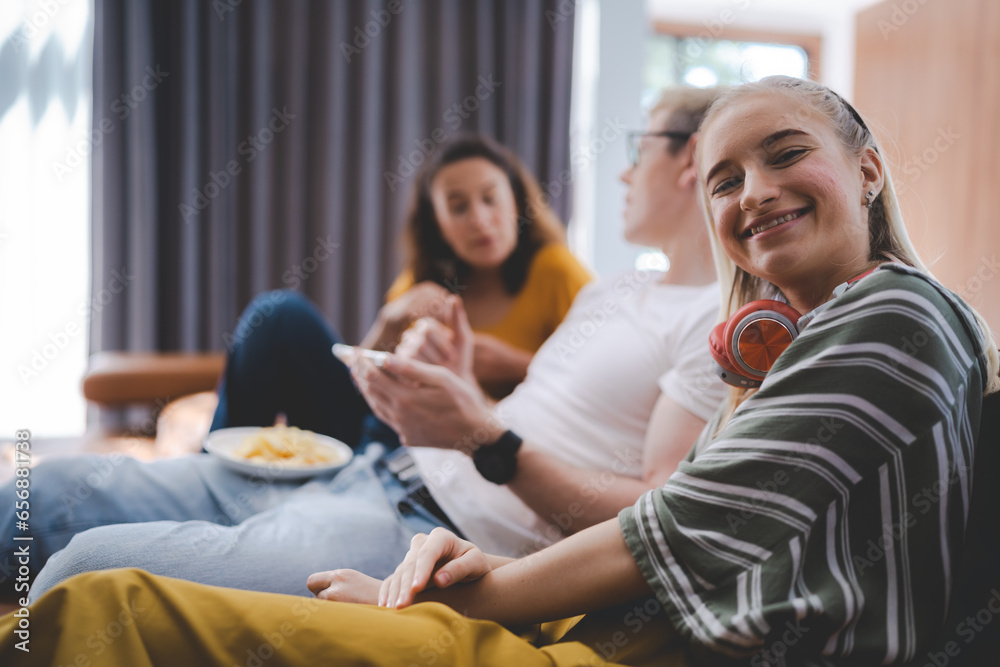 Happy young family enjoy lunch together at home using mobile phone. Addicted online social media cellphone people eating in living room and watching display having fun. Concept of addiction smartphone