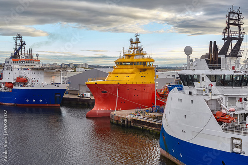 Offshore platform supply vessels in port moored closely together.