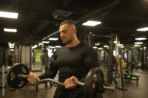 Muscular man during workout in the gym. 
