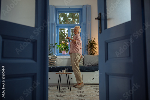 Elderly woman dancing in her apartment