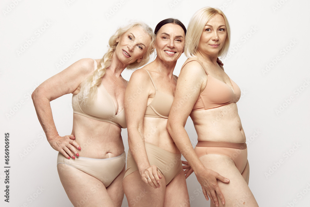 Beautiful senior women with healthy well-kept skin and body standing in underwear against grey studio background. Concept of age, natural beauty. body and skin care, healthy lifestyle