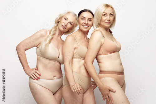Beautiful senior women with healthy well-kept skin and body standing in underwear against grey studio background. Concept of age, natural beauty. body and skin care, healthy lifestyle