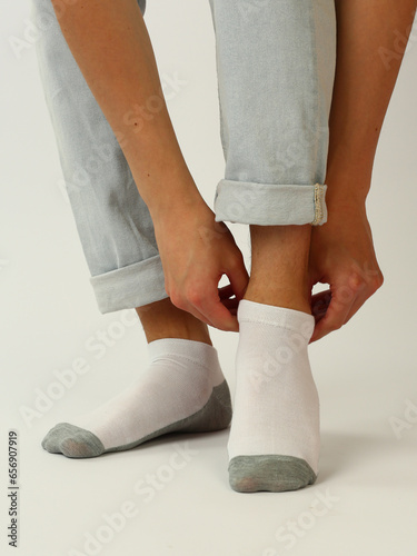 white and gray socks with copy space on human feet close up photo on white background