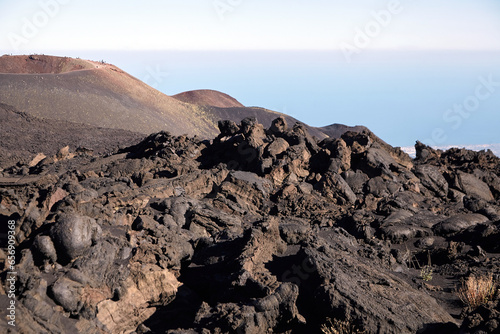 Mount Etna, Sicily, Italy. Slopes of volcano are covered with volcanic ash and frozen lava. Summer mountain landscape on sunny day