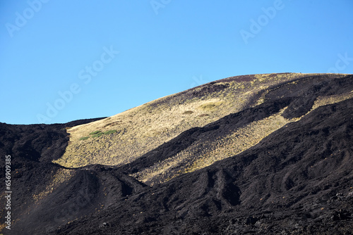 Mount Etna  Sicily  Italy. Slopes of volcano are covered with volcanic ash and frozen lava. Summer mountain landscape on sunny day