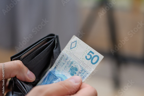 Banknot 50 złotych polskich pln wyciągany z portfela, płacić za zakupy