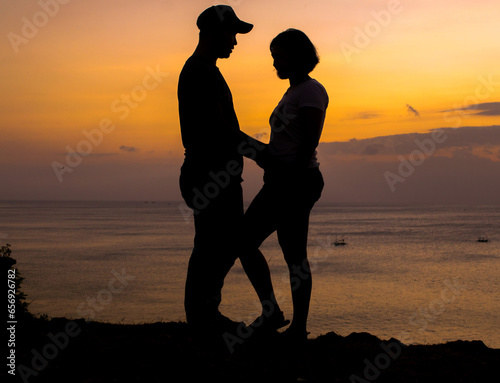 silhouette of a couple on beach sunset photo
