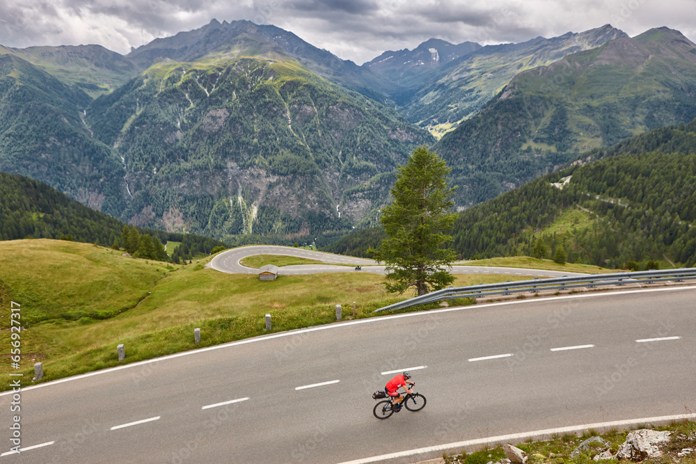Cyclist in alpine serpentine mountain road. Highlight route in Austria