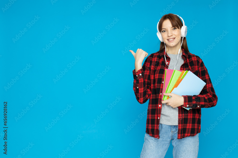 A young girl in headphones and with books in her hands A young girl in headphones and with books in her hands
