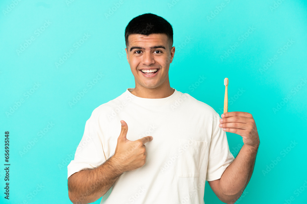 Young handsome man brushing teeth over isolated blue background with surprise facial expression Young handsome man brushing teeth over isolated blue background with surprise facial expression