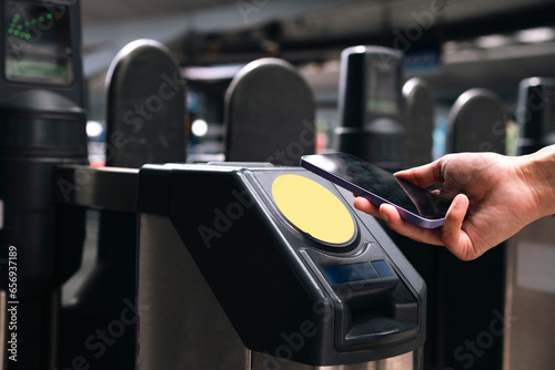 Hand of businesswoman scanning through smart phone at turnstile photo