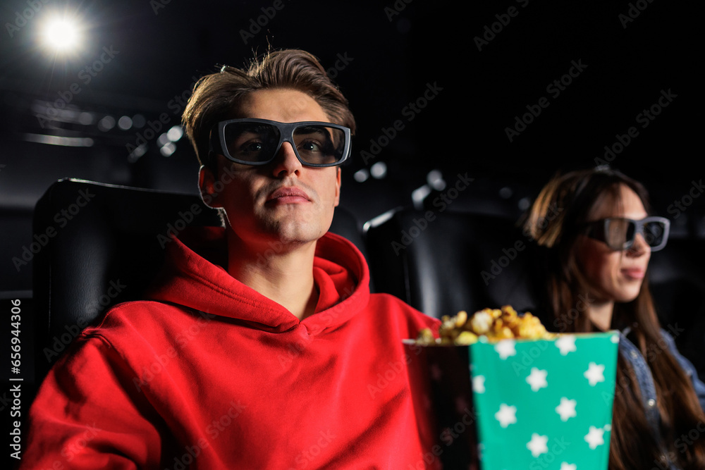 Portrait of a man in 3D glasses eating popcorn and watching a movie. Watching movies in the cinema Portrait of a man in 3D glasses eating popcorn and watching a movie. Watching movies in the cinema
