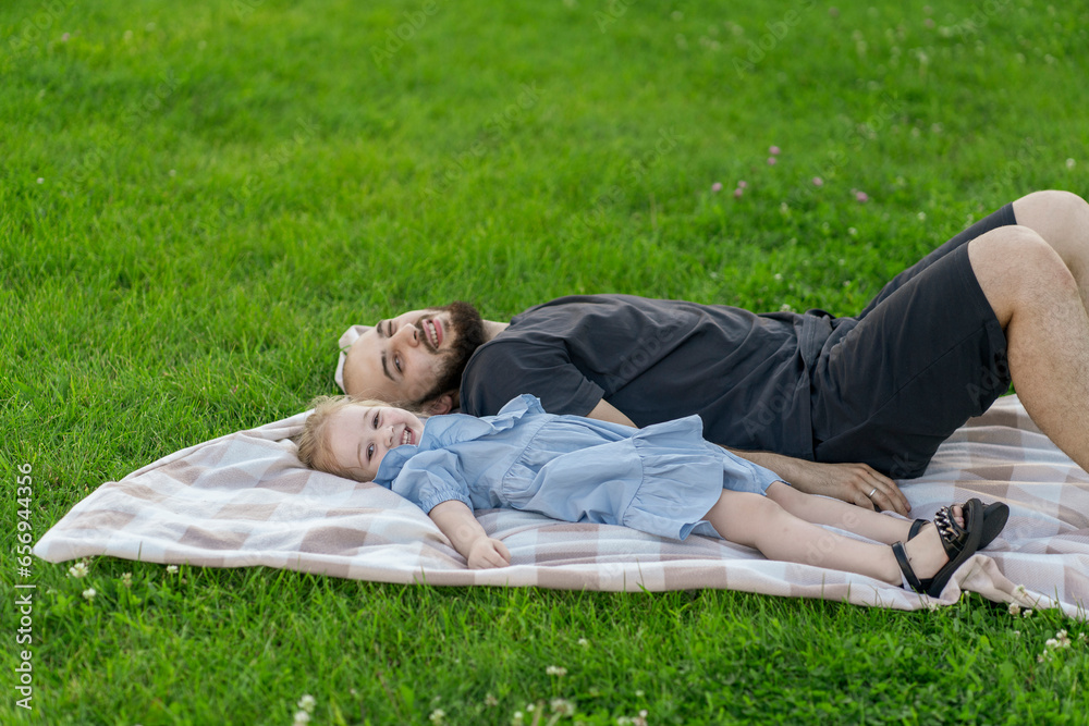 young father and daughter laying on the lawn and hug each other, love and happiness young father and daughter laying on the lawn and hug each other, love and happiness