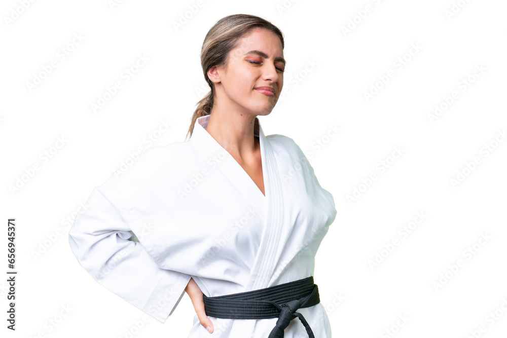 Young Uruguayan woman doing karate over isolated background suffering from backache for having made an effort Young Uruguayan woman doing karate over isolated background suffering from backache for having made an effort