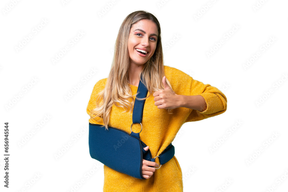 Young Uruguayan woman with broken arm and wearing a sling over isolated background giving a thumbs up gesture Young Uruguayan woman with broken arm and wearing a sling over isolated background giving a thumbs up gesture