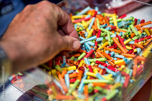 Hand of man choosing from multi colored raffle tickets
