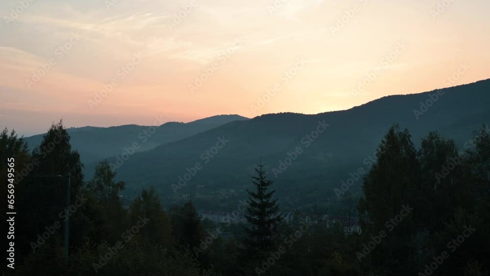 Calm morning video of mountains just before sunrise. Bright colours in sky as sun rises from the horizon beyond the mountains Calm morning video of mountains just before sunrise. Bright colours in sky as sun rises from the horizon beyond the mountains