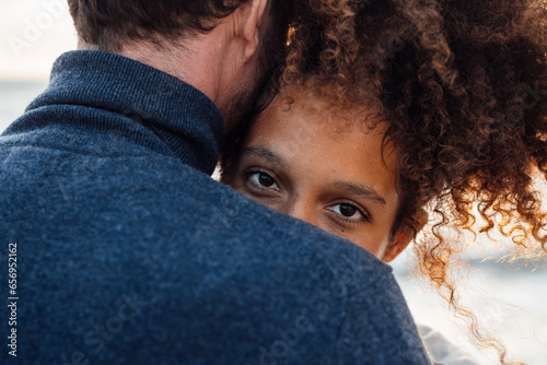 Woman with curly hair embracing boyfriend