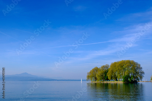 Switzerland, Vaud Canton, Rolle, Blue sky over lake Geneva and Ile de la Harpe island in summer