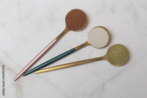 Different types of dietary supplements for health and beauty - collagen, vitamins, biotin, protein powder in spoons
