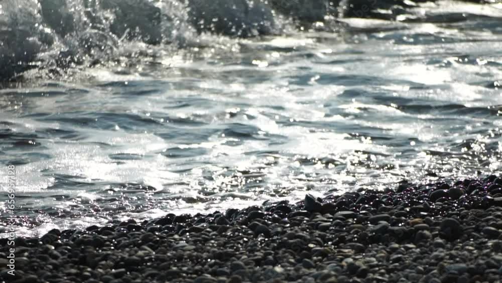 Sea beach wave. Sea waves with soft, foamy waters washing multicolored pebbles on a beach during sunset. Nobody. Holiday recreation concept. Abstract nautical summer ocean sunset nature Slow motion Sea beach wave. Sea waves with soft, foamy waters washing multicolored pebbles on a beach during sunset. Nobody. Holiday recreation concept. Abstract nautical summer ocean sunset nature Slow motion
