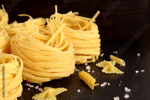 Spaghetti in the form of a nest lies on a black background.