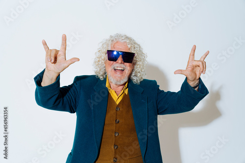 Happy senior man showing horn gesture against white background