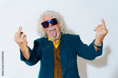 Cheerful man sticking out tongue and showing obscene gesture photo