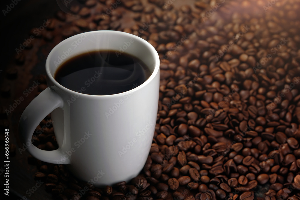 black coffee in white mug with surrounded by roasted coffee beans on dark red wood table black coffee in white mug with surrounded by roasted coffee beans on dark red wood table