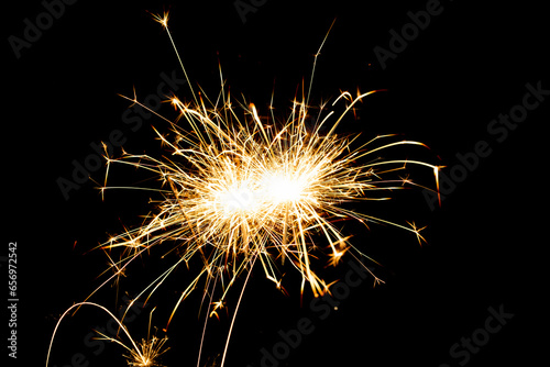 Sparkling burning sparkler on a black background.