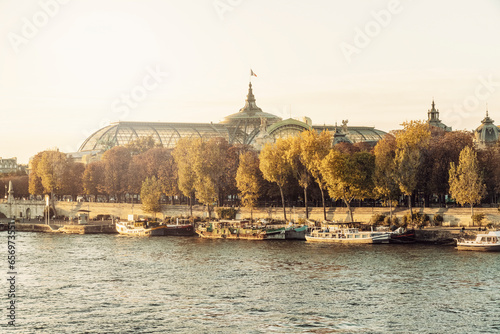 France, Ile-De-France, Paris, Boats moored along Seine river at dusk with Grand Palais in background photo