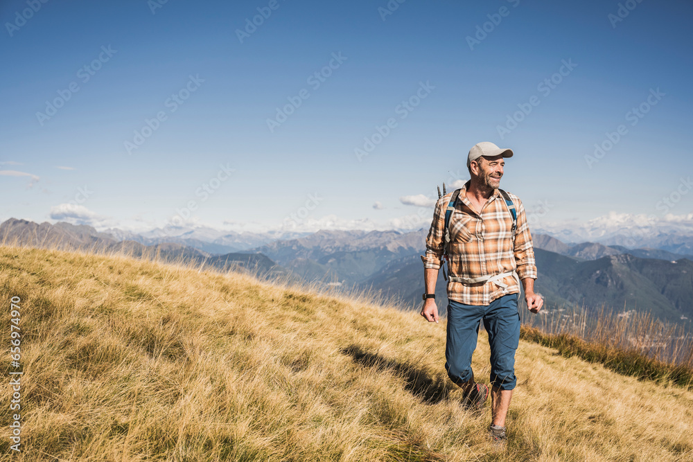 Smiling mature hiker walking and exploring on mountain Smiling mature hiker walking and exploring on mountain