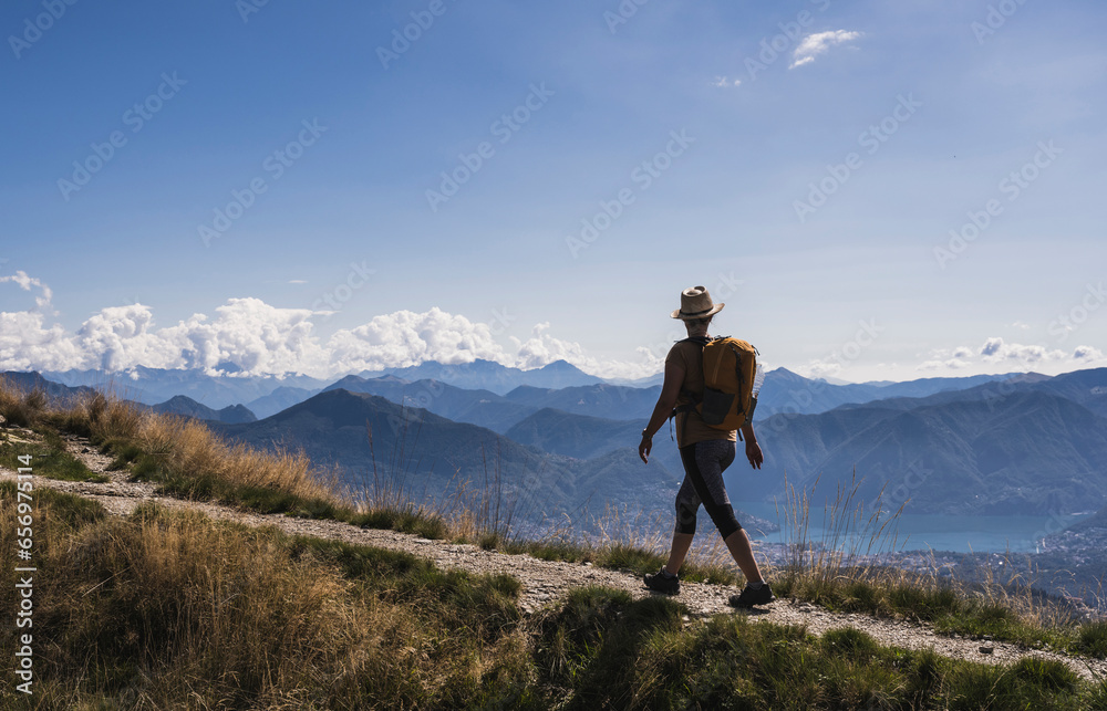 Hiker walking on footpath and looking at mountains Hiker walking on footpath and looking at mountains
